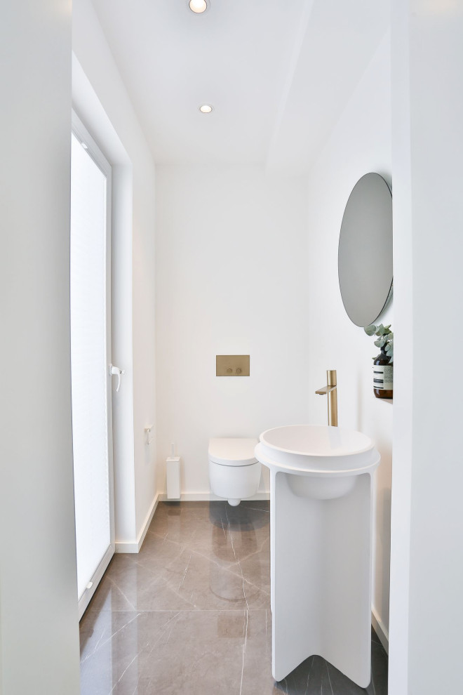 Idee per un piccolo bagno di servizio moderno con WC sospeso, pareti bianche, pavimento in marmo, top in superficie solida, pavimento grigio, top bianco e mobile bagno freestanding