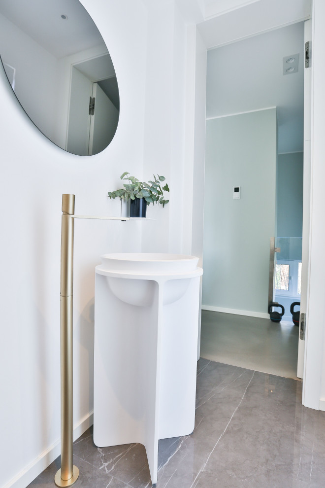 Cette photo montre un petit WC suspendu moderne avec un mur blanc, un sol en marbre, un plan de toilette en surface solide, un sol gris, un plan de toilette blanc et meuble-lavabo sur pied.