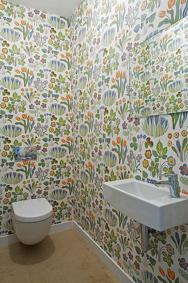 Ispirazione per un bagno di servizio contemporaneo di medie dimensioni con WC sospeso, pareti multicolore, pavimento in travertino, lavabo sospeso e piastrelle beige