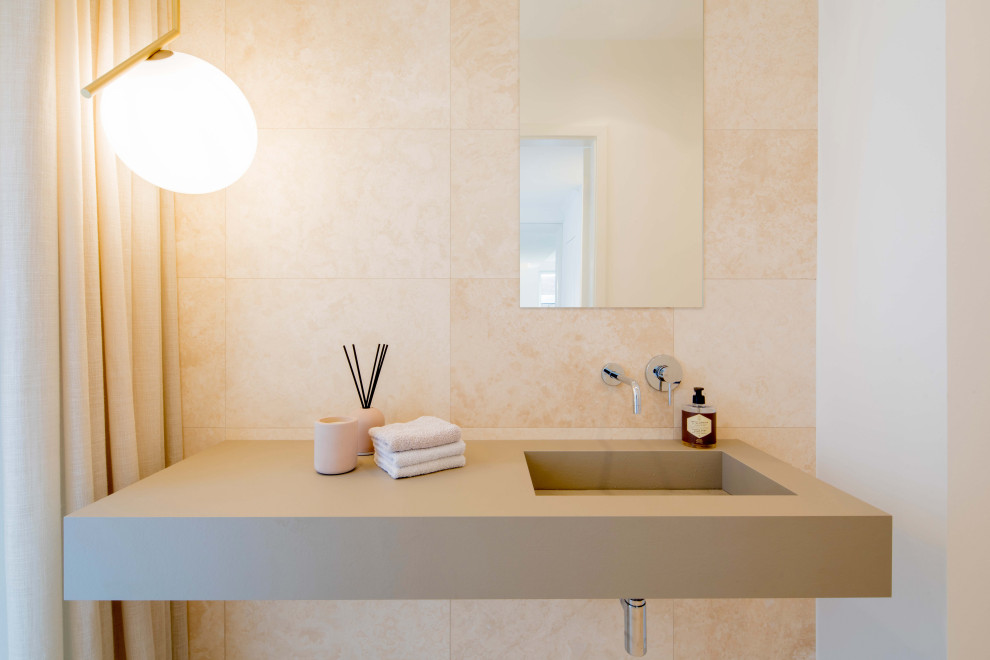 Cette photo montre un grand WC et toilettes tendance avec WC séparés, un carrelage beige, du carrelage en travertin, un mur beige, un sol en travertin, un lavabo intégré, un plan de toilette en béton, un sol beige, un plan de toilette marron et meuble-lavabo suspendu.