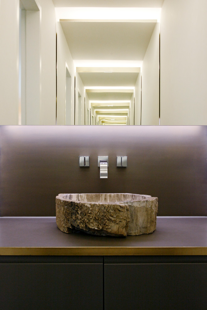 Idée de décoration pour un WC et toilettes minimaliste en bois foncé avec une vasque, un placard à porte plane et un mur marron.