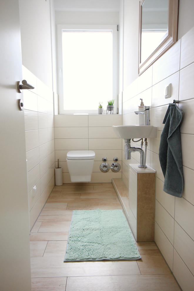 Kleine Moderne Gästetoilette mit Wandtoilette, weißen Fliesen, Porzellanfliesen, weißer Wandfarbe, Zementfliesen für Boden, Wandwaschbecken und beigem Boden in Frankfurt am Main