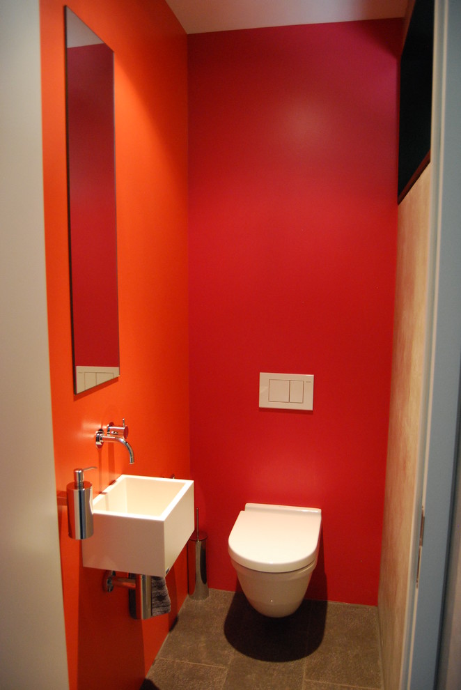 Kleine Moderne Gästetoilette mit Wandtoilette mit Spülkasten, roter Wandfarbe, Terrakottaboden, Wandwaschbecken, Mineralwerkstoff-Waschtisch und grauem Boden in Stuttgart