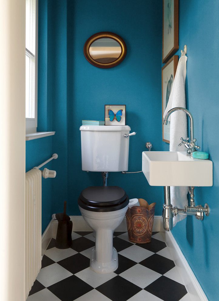 Kleine Stilmix Gästetoilette mit schwarz-weißen Fliesen, blauer Wandfarbe, Wandwaschbecken und Wandtoilette mit Spülkasten in Berlin