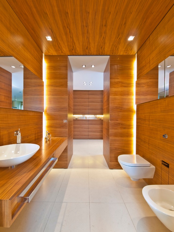 Réalisation d'un grand WC suspendu design en bois brun avec une vasque, un placard à porte plane, un plan de toilette en bois, un mur marron et un plan de toilette marron.