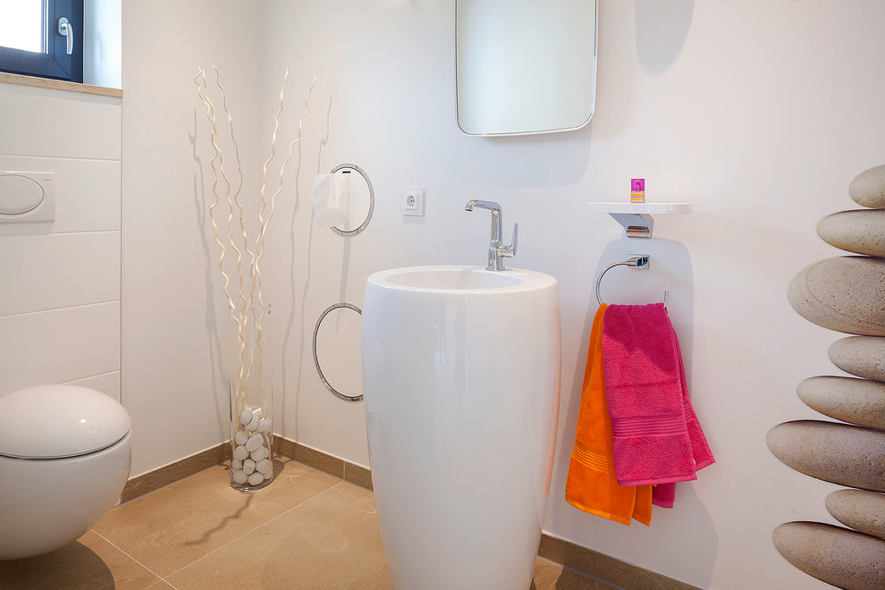 На фото: туалет среднего размера в современном стиле с белыми стенами и раковиной с пьедесталом с