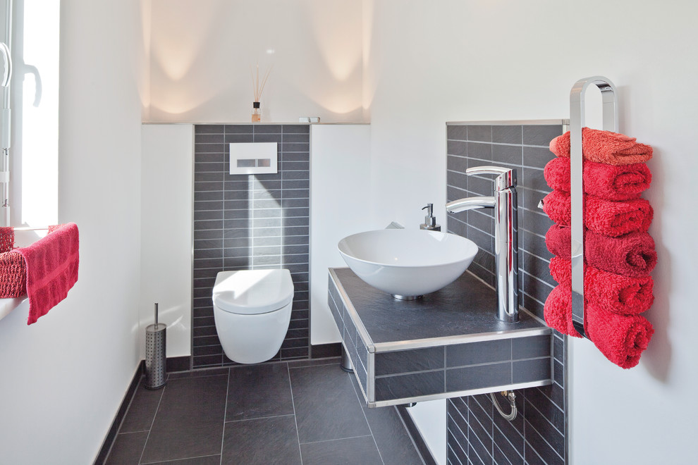 Idee per un bagno di servizio contemporaneo con pareti bianche, pavimento grigio, WC monopezzo, piastrelle grigie, lavabo a bacinella e top grigio