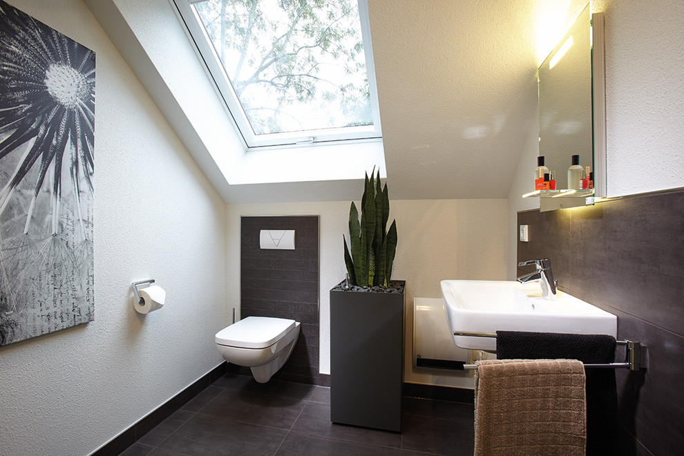 Exempel på ett modernt vit vitt toalett, med en vägghängd toalettstol, grå kakel, beige väggar, klinkergolv i terrakotta, ett väggmonterat handfat och grått golv