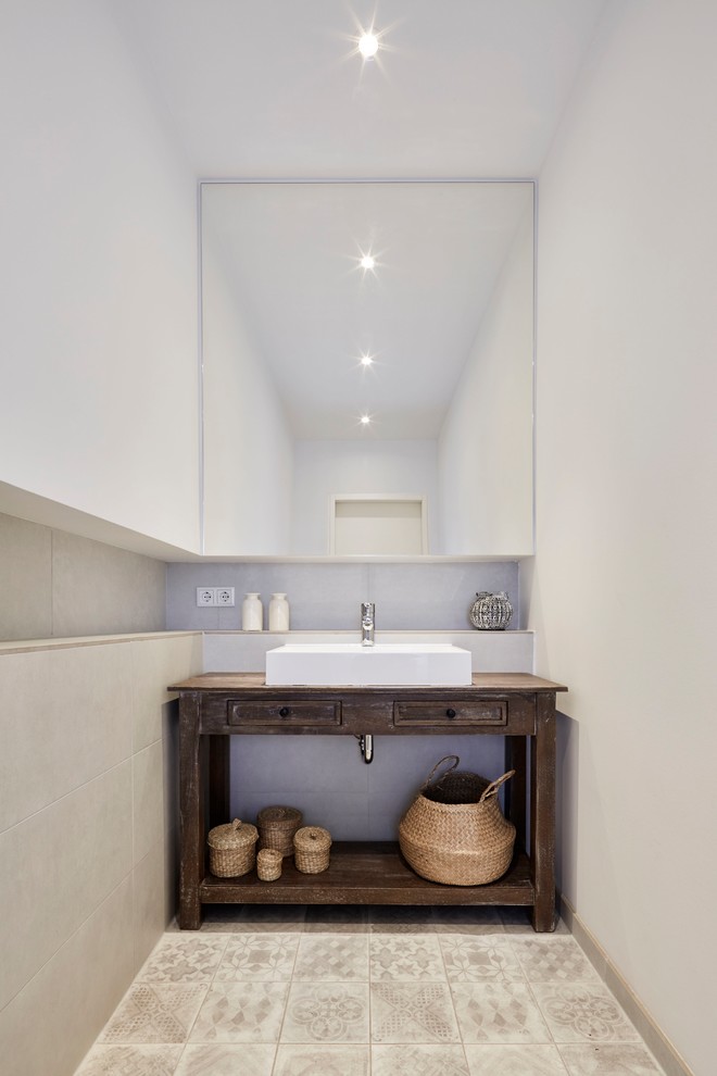 Shabby-Look Gästetoilette mit weißer Wandfarbe, Zementfliesen für Boden, Aufsatzwaschbecken und beigem Boden in Essen