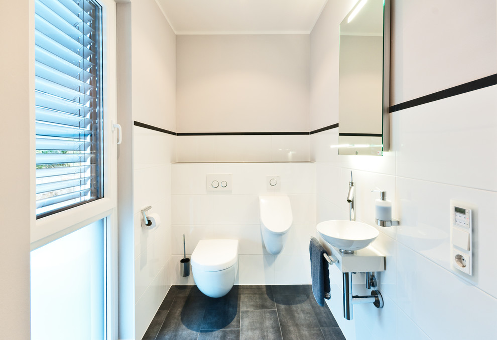 Immagine di un bagno di servizio minimal di medie dimensioni con piastrelle bianche, piastrelle in ceramica, pavimento con piastrelle in ceramica, lavabo a bacinella, orinatoio e pareti bianche