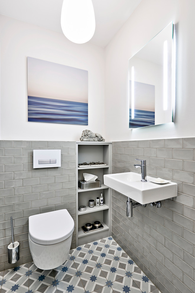 Design ideas for a small contemporary cloakroom in Hamburg with a two-piece toilet, grey tiles, metro tiles, beige walls, ceramic flooring, a wall-mounted sink, beige floors and a floating vanity unit.
