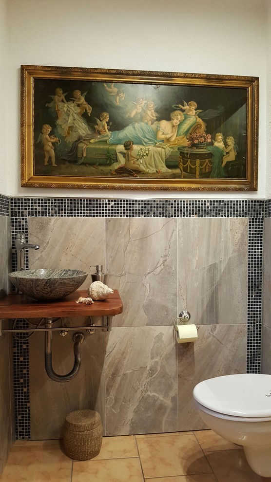 Diseño de aseo clásico pequeño con sanitario de pared, baldosas y/o azulejos grises, baldosas y/o azulejos en mosaico, paredes blancas, suelo de baldosas de cerámica, encimera de granito y lavabo sobreencimera