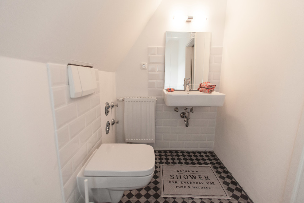 Свежая идея для дизайна: маленький туалет в скандинавском стиле с инсталляцией, белой плиткой, плиткой кабанчик, белыми стенами, полом из винила, разноцветным полом и подвесной раковиной для на участке и в саду - отличное фото интерьера