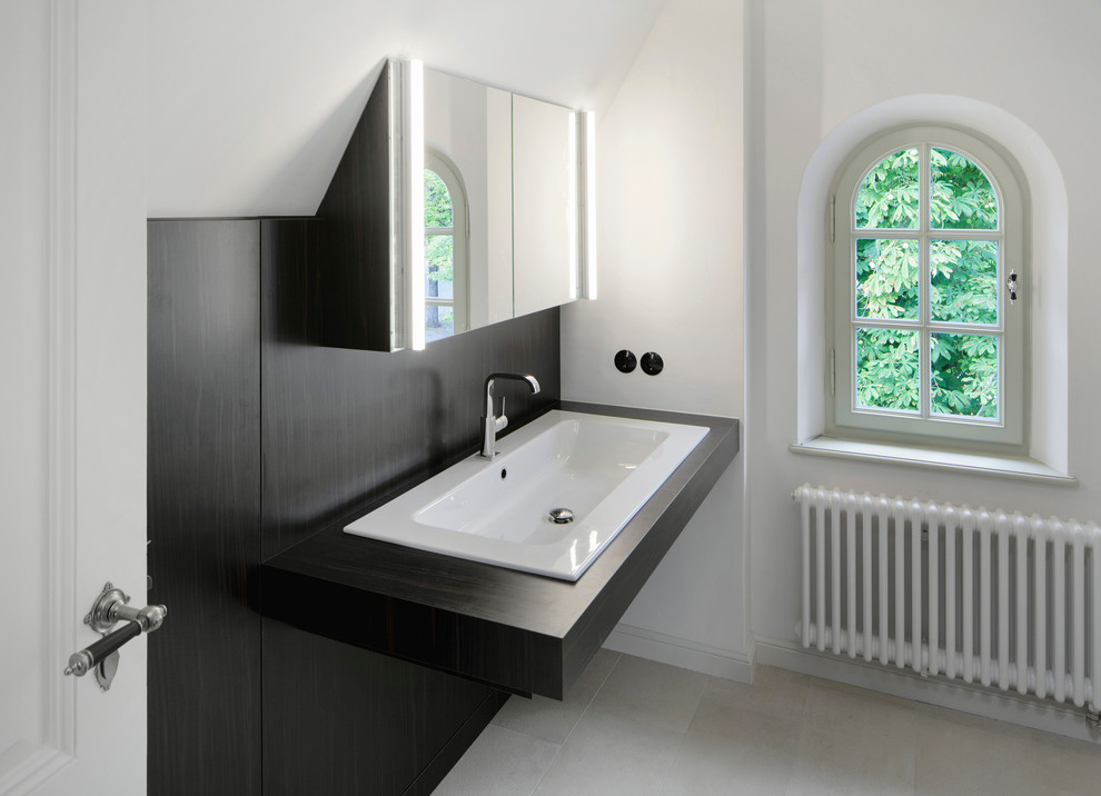 Foto di un bagno di servizio chic con ante in legno bruno, lavabo da incasso, top in legno e top nero