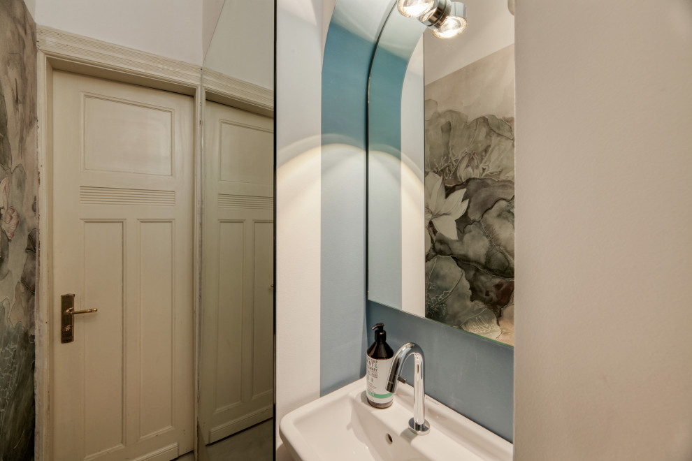 Foto de aseo contemporáneo pequeño con sanitario de pared, baldosas y/o azulejos grises, paredes blancas, lavabo suspendido, suelo gris y papel pintado