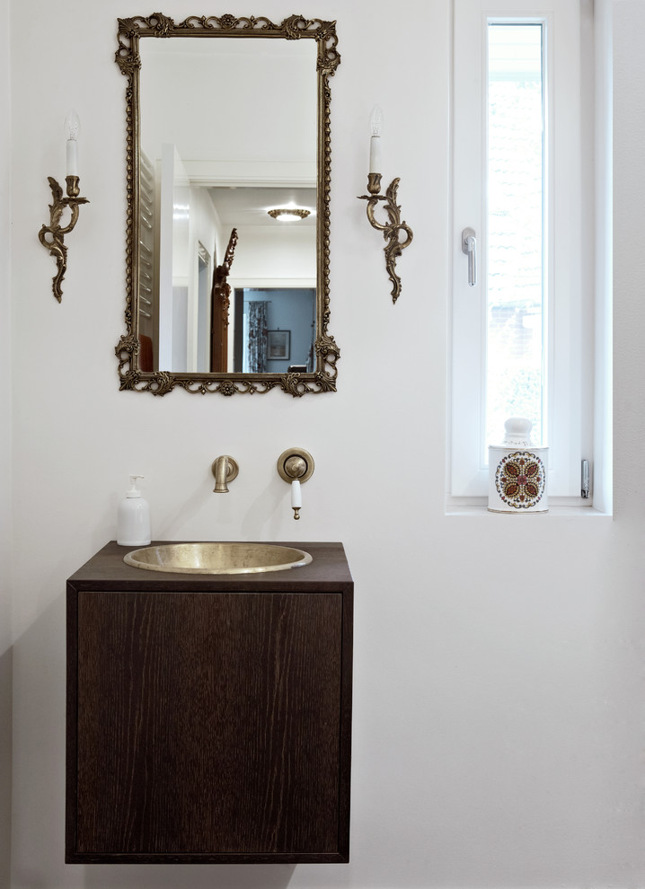 Idées déco pour un WC et toilettes classique en bois foncé avec un lavabo posé, un plan de toilette en bois, un mur blanc, un placard à porte plane et un plan de toilette marron.