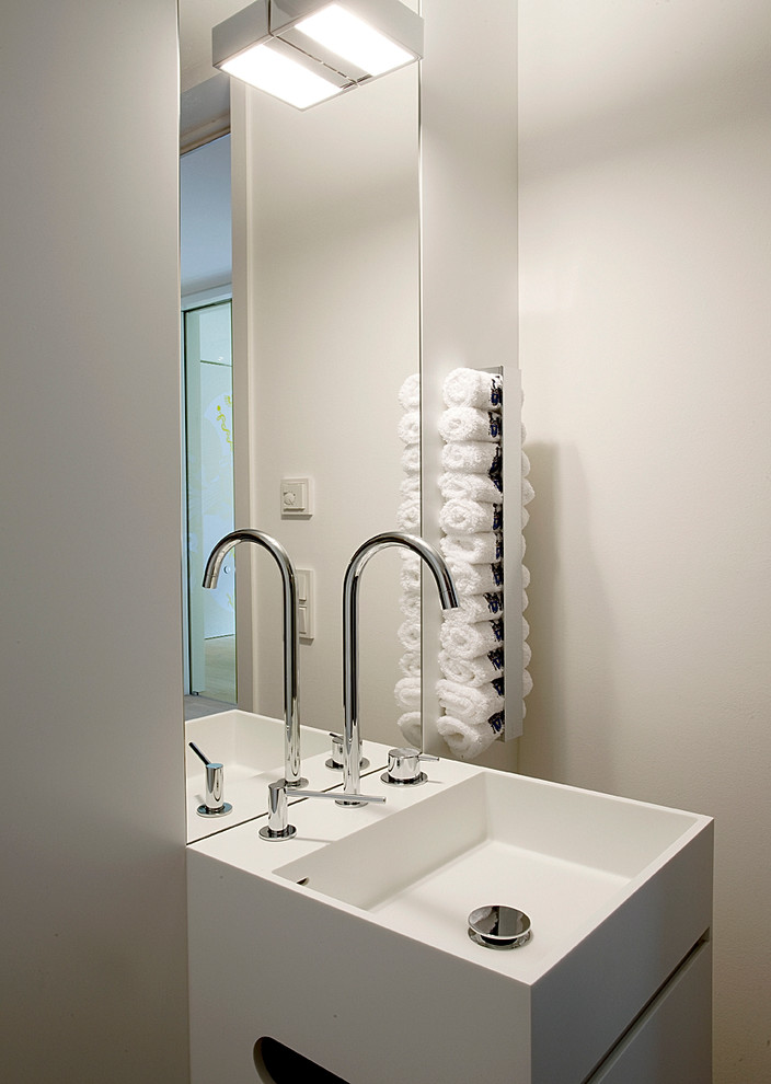 Trendy powder room photo in Munich with flat-panel cabinets, white cabinets, beige walls and a pedestal sink