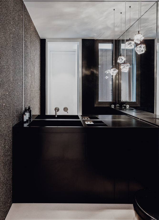 Inspiration pour un WC et toilettes minimaliste avec un placard à porte plane, des portes de placard noires, WC séparés, des dalles de pierre, un mur gris, sol en béton ciré, un plan de toilette en surface solide, un sol gris et un plan de toilette noir.