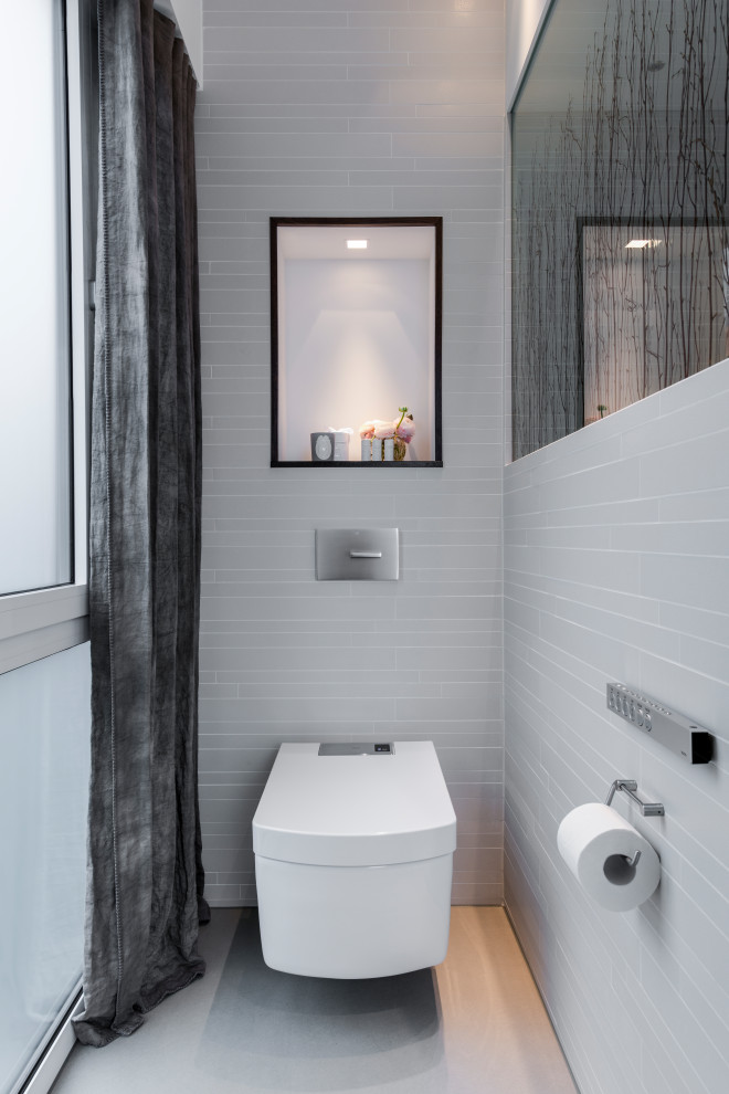 Foto di un piccolo bagno di servizio minimal con WC sospeso, pavimento grigio e piastrelle grigie