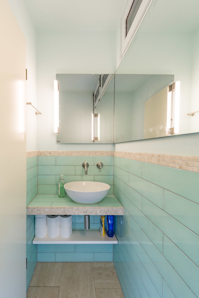 На фото: маленький туалет в современном стиле с инсталляцией, синей плиткой, керамической плиткой, синими стенами, полом из известняка, настольной раковиной, столешницей из плитки и бежевым полом для на участке и в саду