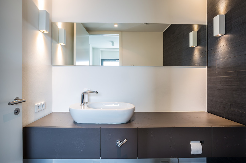 This is an example of a small contemporary cloakroom in Cologne with flat-panel cabinets, white walls and a vessel sink.