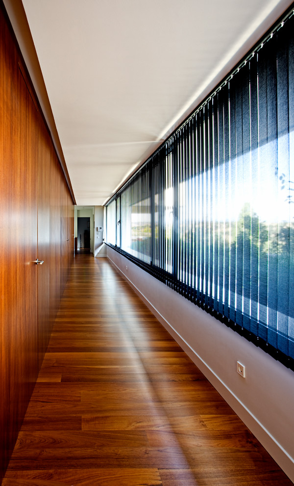 Idées déco pour un grand couloir contemporain avec un sol en bois brun.