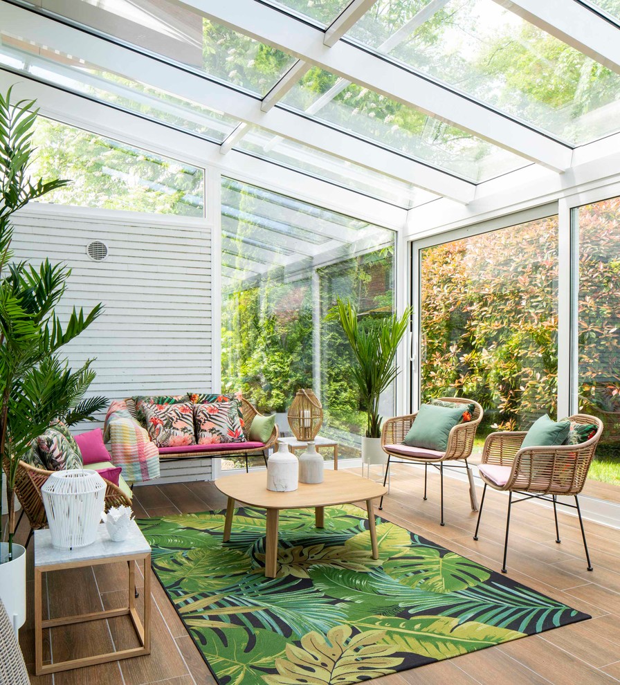 Foto di una grande veranda tropicale con pavimento con piastrelle in ceramica, nessun camino, soffitto in vetro e pavimento marrone