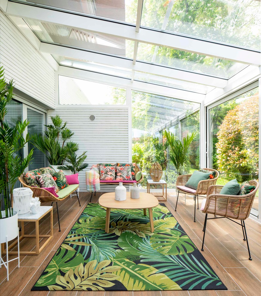 Ispirazione per una grande veranda tropicale con pavimento in legno massello medio, soffitto in vetro, pavimento marrone e nessun camino