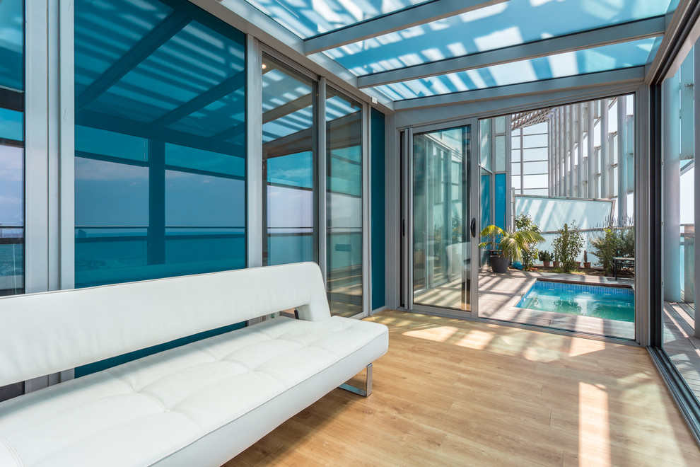 Immagine di una veranda design di medie dimensioni con parquet chiaro, nessun camino, soffitto in vetro e pavimento beige