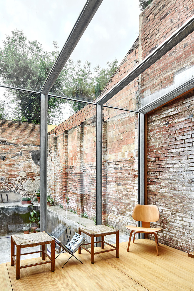 Foto de galería urbana de tamaño medio sin chimenea con suelo de madera clara y techo de vidrio