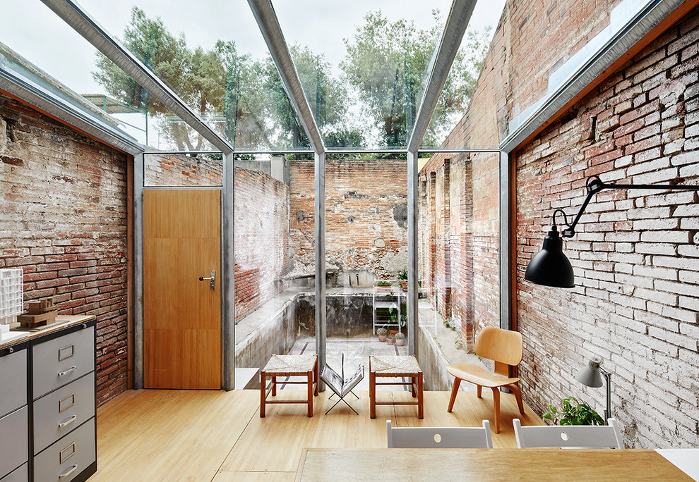 Foto de galería industrial de tamaño medio sin chimenea con techo de vidrio y suelo de madera en tonos medios