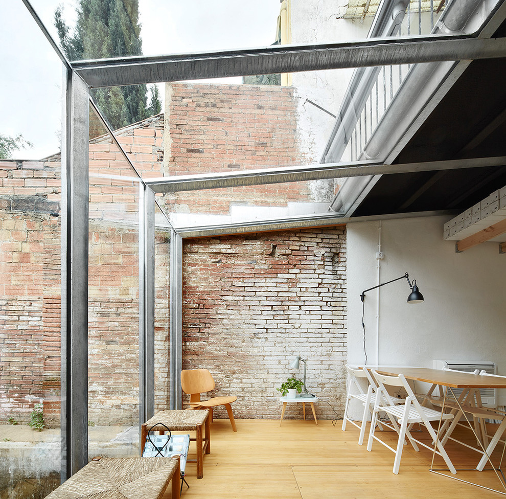 Idee per una veranda industriale di medie dimensioni con parquet chiaro, nessun camino e soffitto in vetro