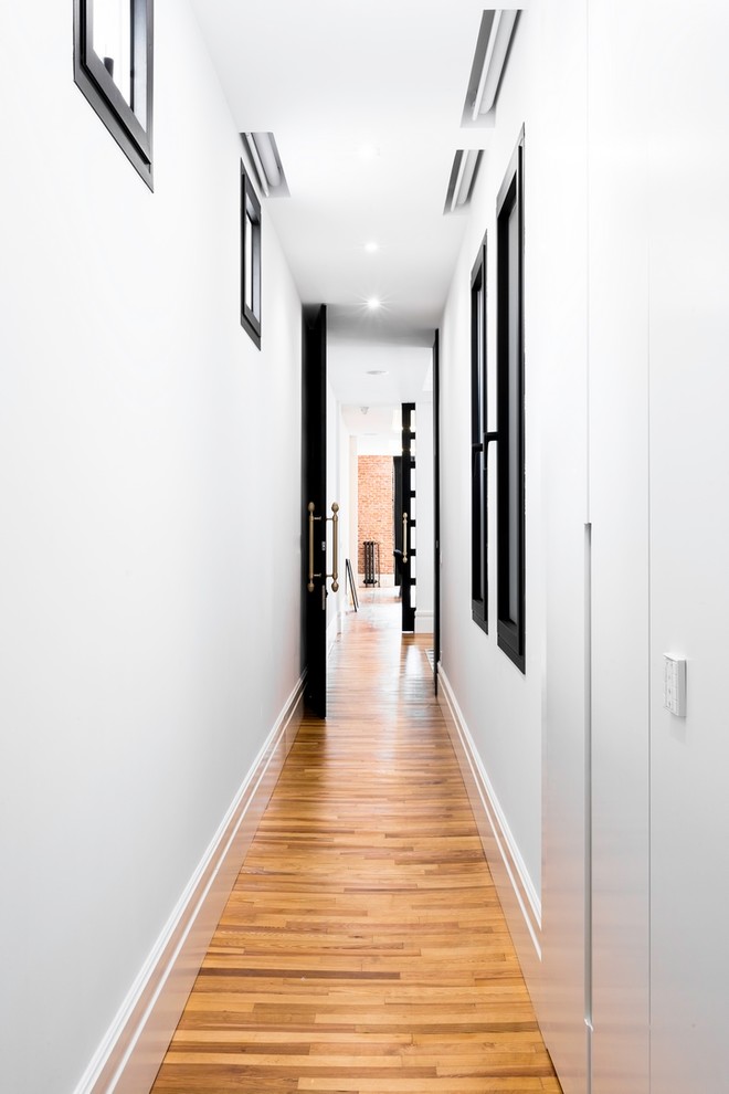 Imagen de recibidores y pasillos clásicos renovados grandes con suelo de madera en tonos medios y suelo marrón