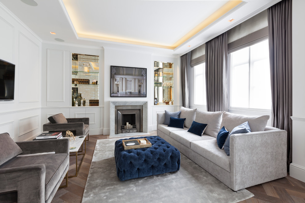 Diseño de sala de estar tradicional renovada con paredes blancas, suelo de madera en tonos medios, todas las chimeneas y televisor colgado en la pared