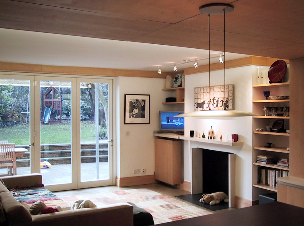 Imagen de sala de estar abierta contemporánea con paredes blancas, marco de chimenea de piedra y televisor independiente