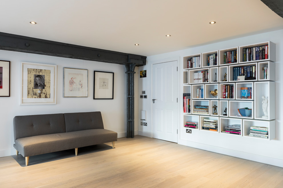 Стильный дизайн: огромная открытая гостиная комната в стиле лофт с с книжными шкафами и полками, белыми стенами, светлым паркетным полом и телевизором в углу без камина - последний тренд