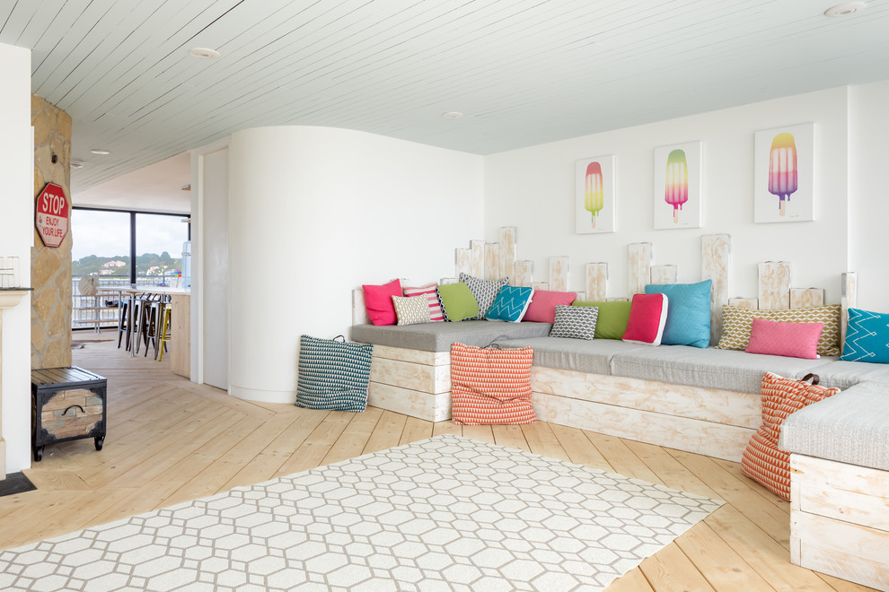 На фото: большая открытая гостиная комната в морском стиле с белыми стенами, светлым паркетным полом и бежевым полом