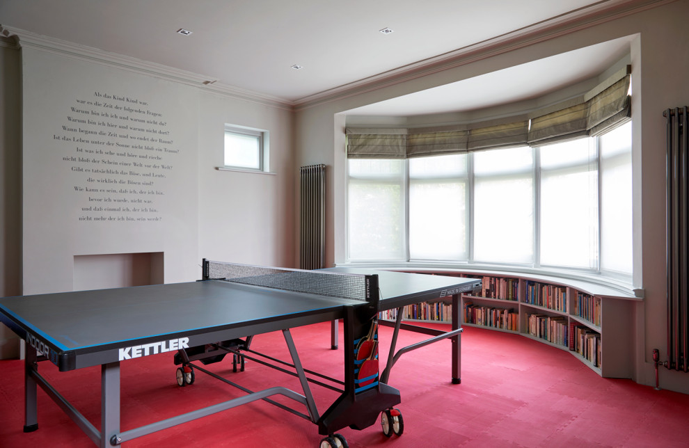 This is an example of a large contemporary games room in London with grey walls, vinyl flooring and red floors.