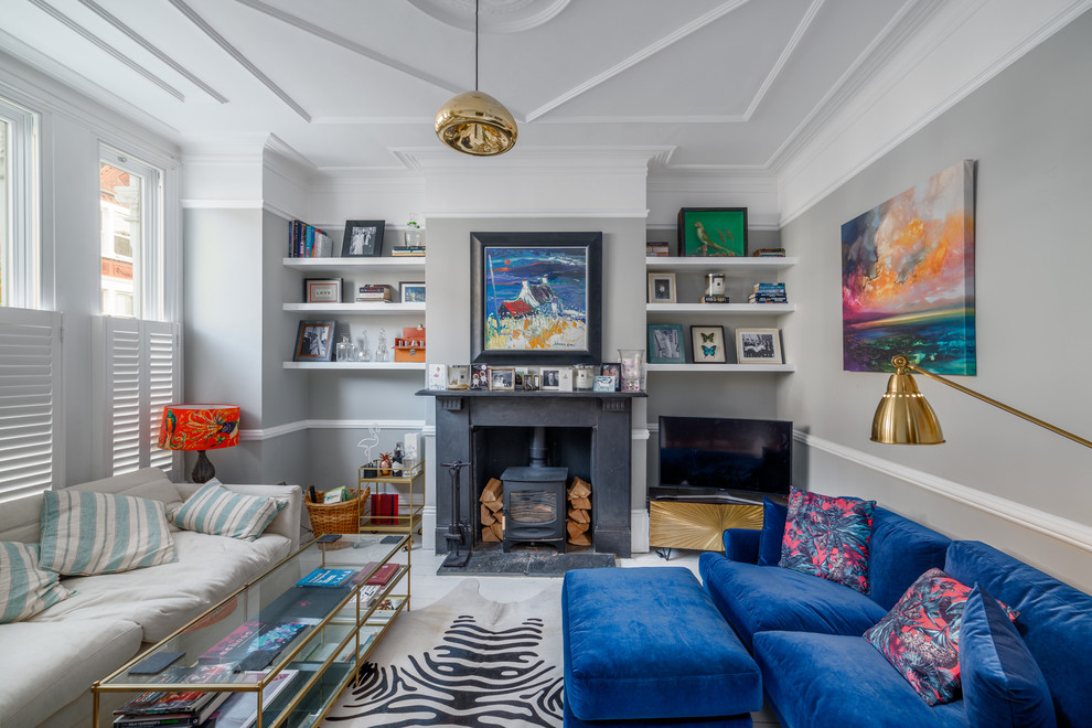 Diseño de sala de estar ecléctica con paredes grises, suelo de madera pintada, estufa de leña, suelo blanco, televisor independiente y alfombra