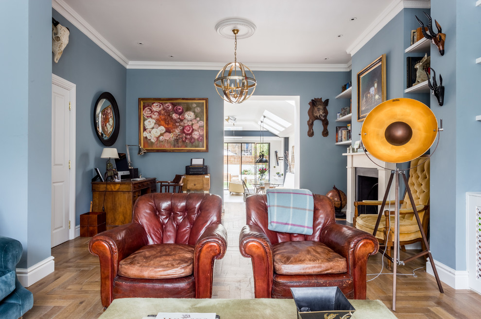 Design ideas for a medium sized eclectic enclosed games room in London with a reading nook, blue walls, medium hardwood flooring, a standard fireplace, a metal fireplace surround and brown floors.