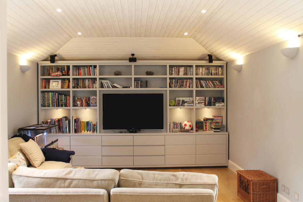 Imagen de sala de juegos en casa cerrada minimalista pequeña sin chimenea con paredes grises, televisor colgado en la pared y suelo beige