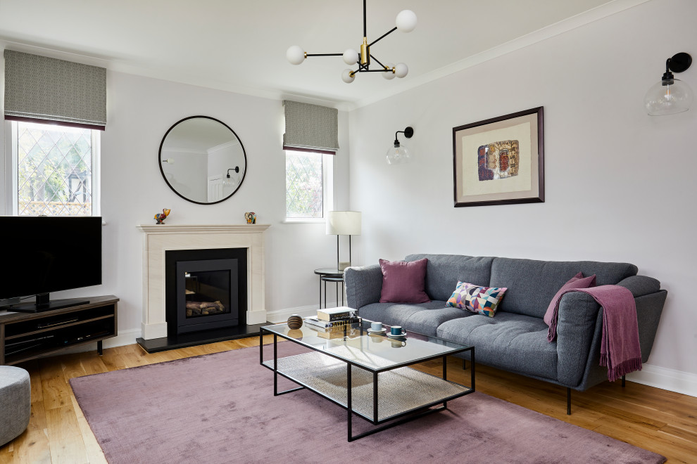 Пример оригинального дизайна: гостиная комната среднего размера в стиле неоклассика (современная классика) с фиолетовыми стенами, печью-буржуйкой, отдельно стоящим телевизором и светлым паркетным полом
