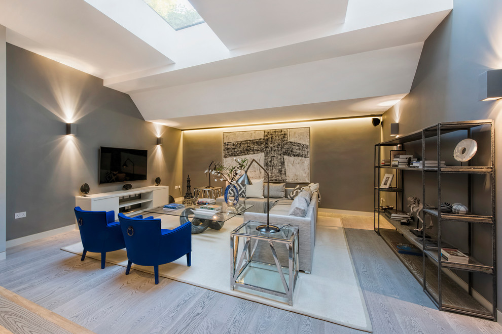 Offenes Modernes Wohnzimmer ohne Kamin mit grauer Wandfarbe und TV-Wand in London