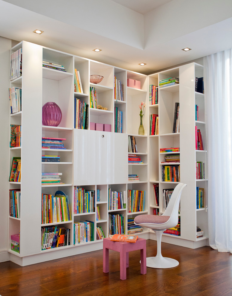 Foto di un soggiorno minimal con libreria e pavimento in legno massello medio