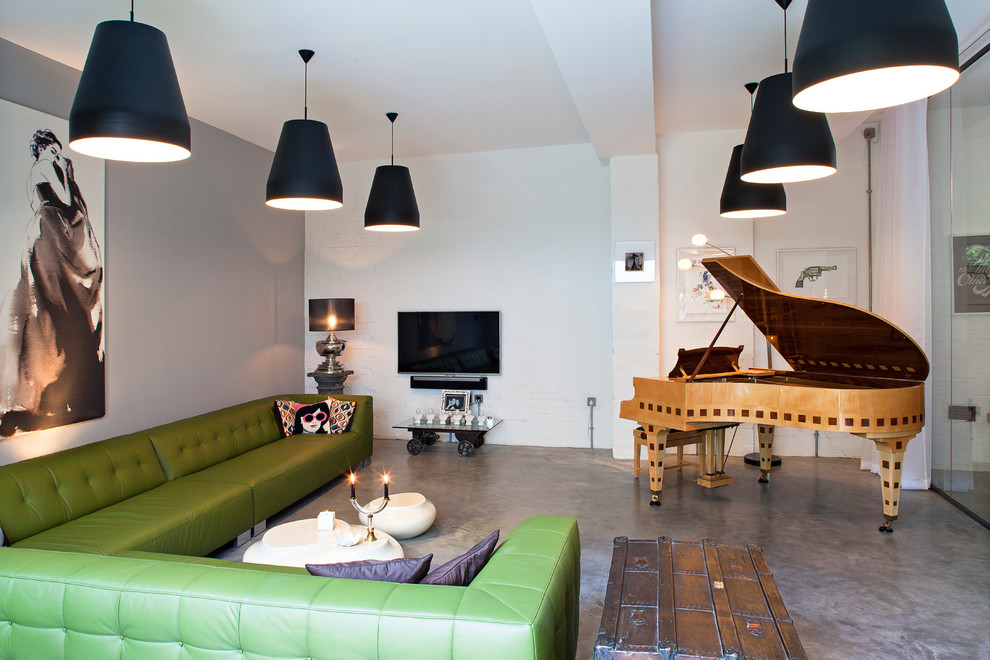Cette image montre une salle de séjour design avec une salle de musique, un mur multicolore, sol en béton ciré et un téléviseur fixé au mur.