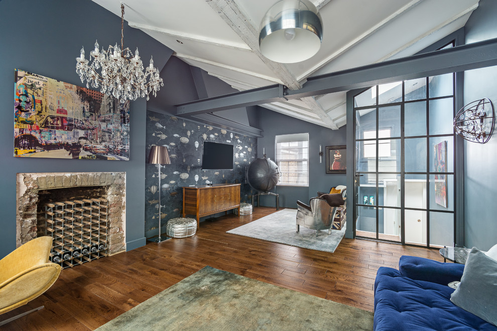 Offenes Industrial Wohnzimmer mit blauer Wandfarbe, hellem Holzboden, Kamin, Kaminumrandung aus Stein, TV-Wand und braunem Boden in London