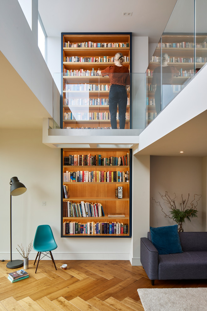 Offene Moderne Bibliothek mit weißer Wandfarbe und hellem Holzboden in London