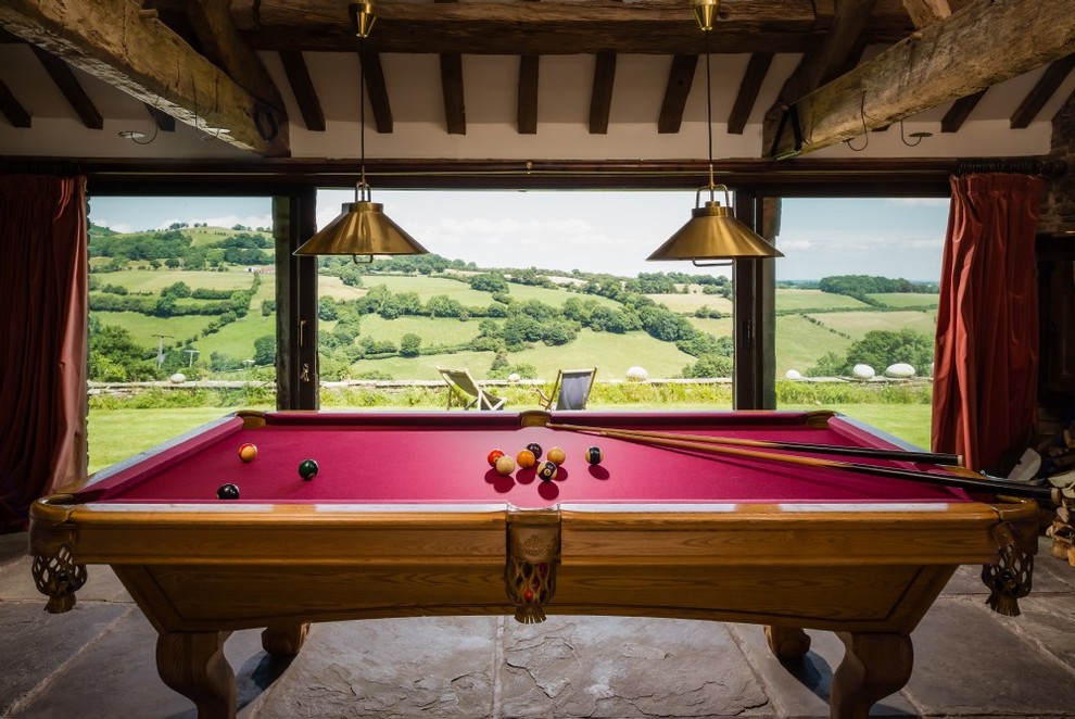 This is an example of a medium sized rustic enclosed games room in Hertfordshire with a game room, white walls, limestone flooring and grey floors.