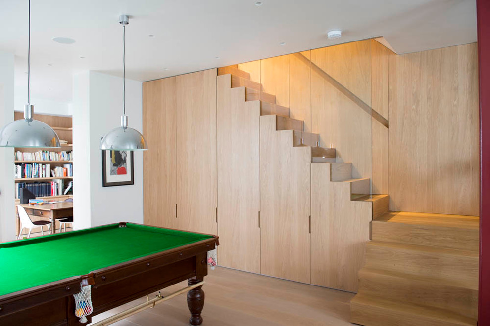 Inspiration for a medium sized contemporary games room in London with white walls and light hardwood flooring.
