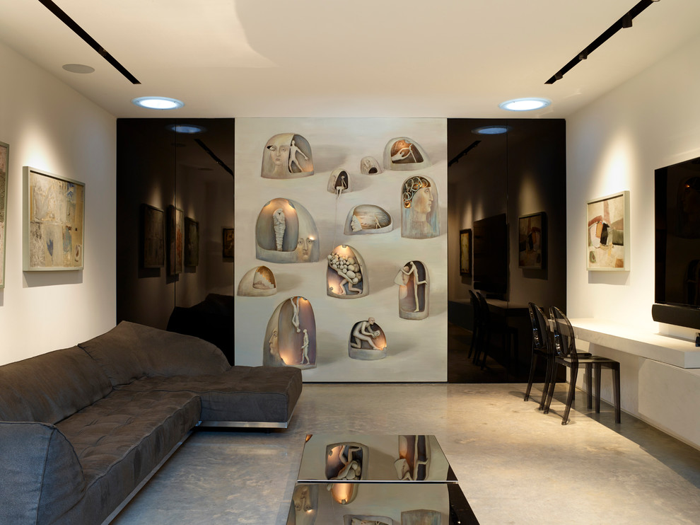 Пример оригинального дизайна: изолированная гостиная комната среднего размера в современном стиле с белыми стенами, бетонным полом, телевизором на стене и серым полом